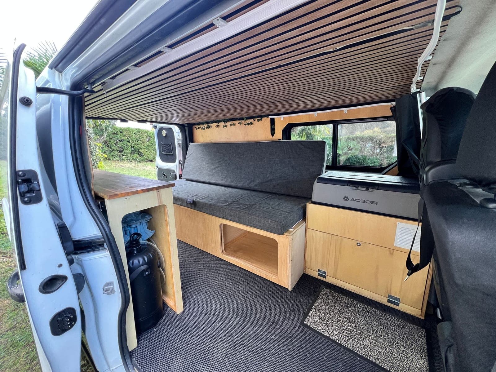 Banquette et bloc cuisine en bois clair d'un van aménagé Vanzon Explorer