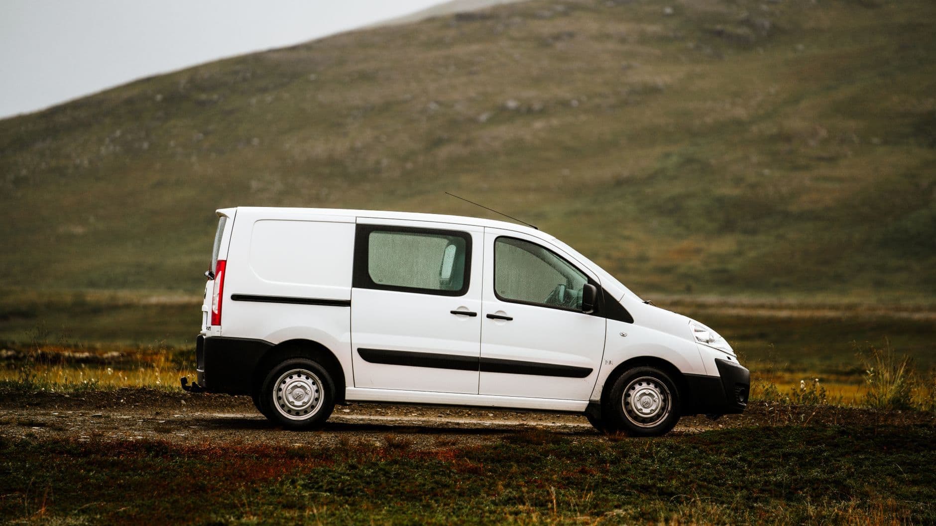 Fourgon blanc aménagé sur une route de forêt