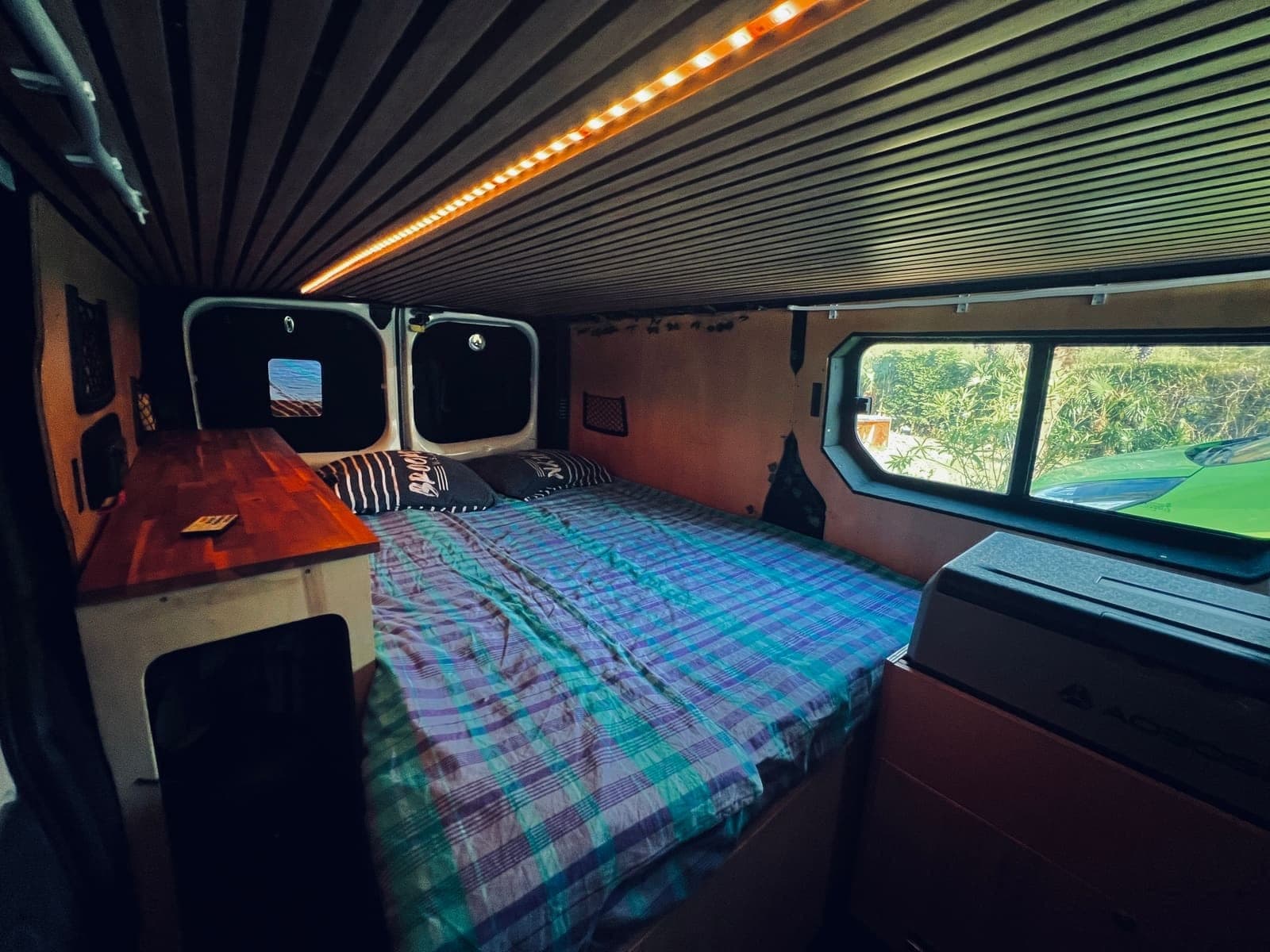 Couchage éclairé par les LED d'ambiance d'un van aménagé Vanzon Explorer