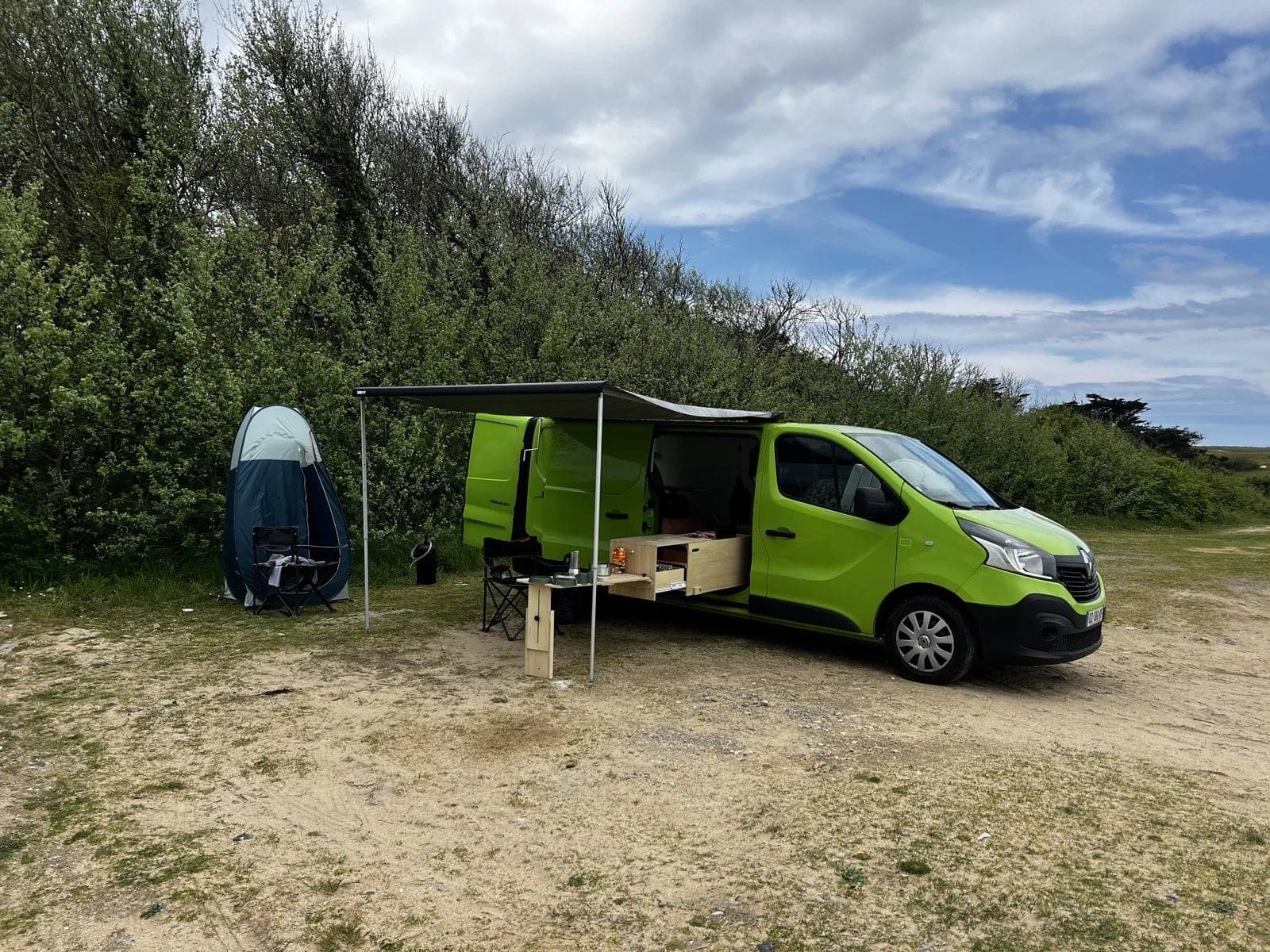 Van aménagé Vanzon Explorer installé en bord de mer, auvent déployé