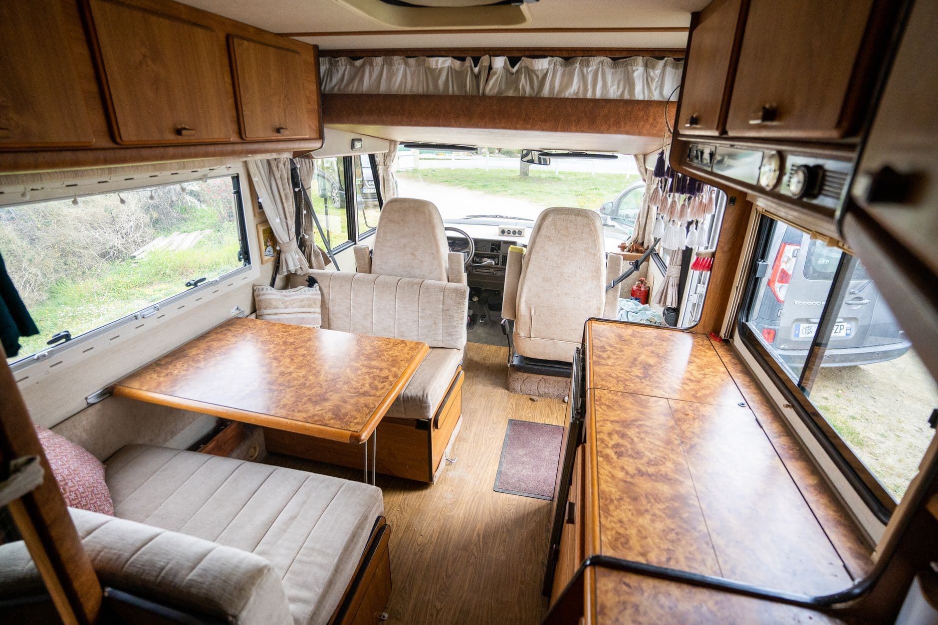 Interior of a classic camper van with wooden furniture, perfect for travel and adventure enthusiasts.