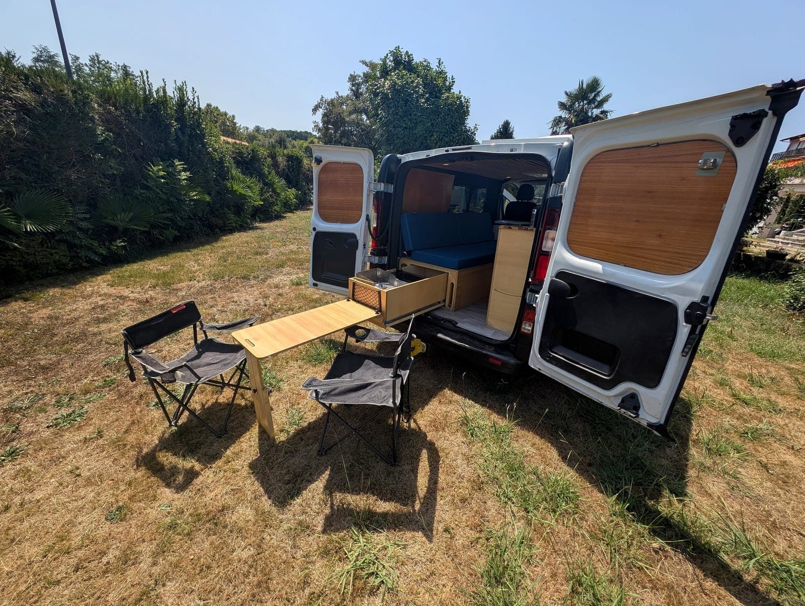 Van aménagé Vanzon Explorer avec table et chaises installées dehors