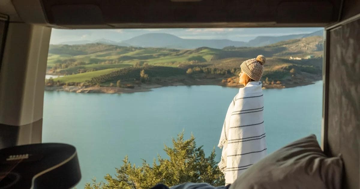 Van aménagé cosy sur une route de campagne en France — road trip en van